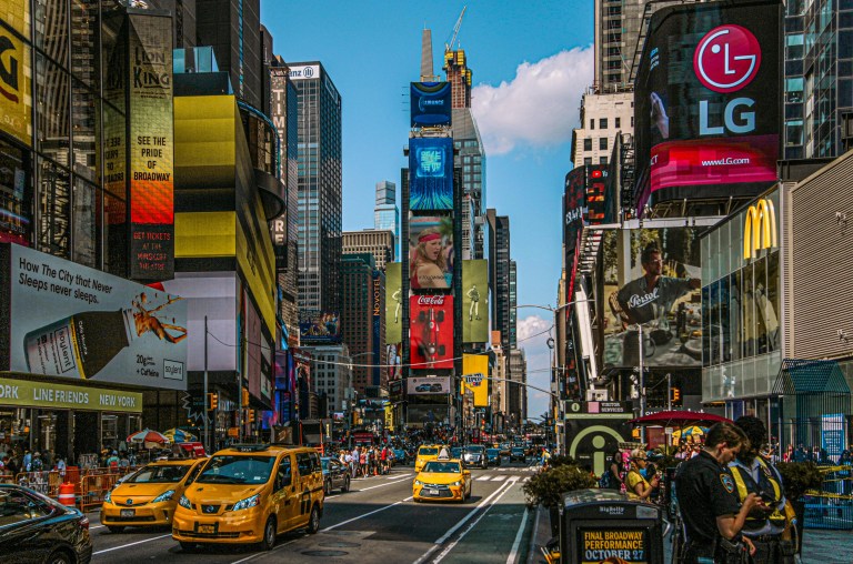 Digital branding billboards displaying vibrant advertisements across New York City’s Times Square at night.