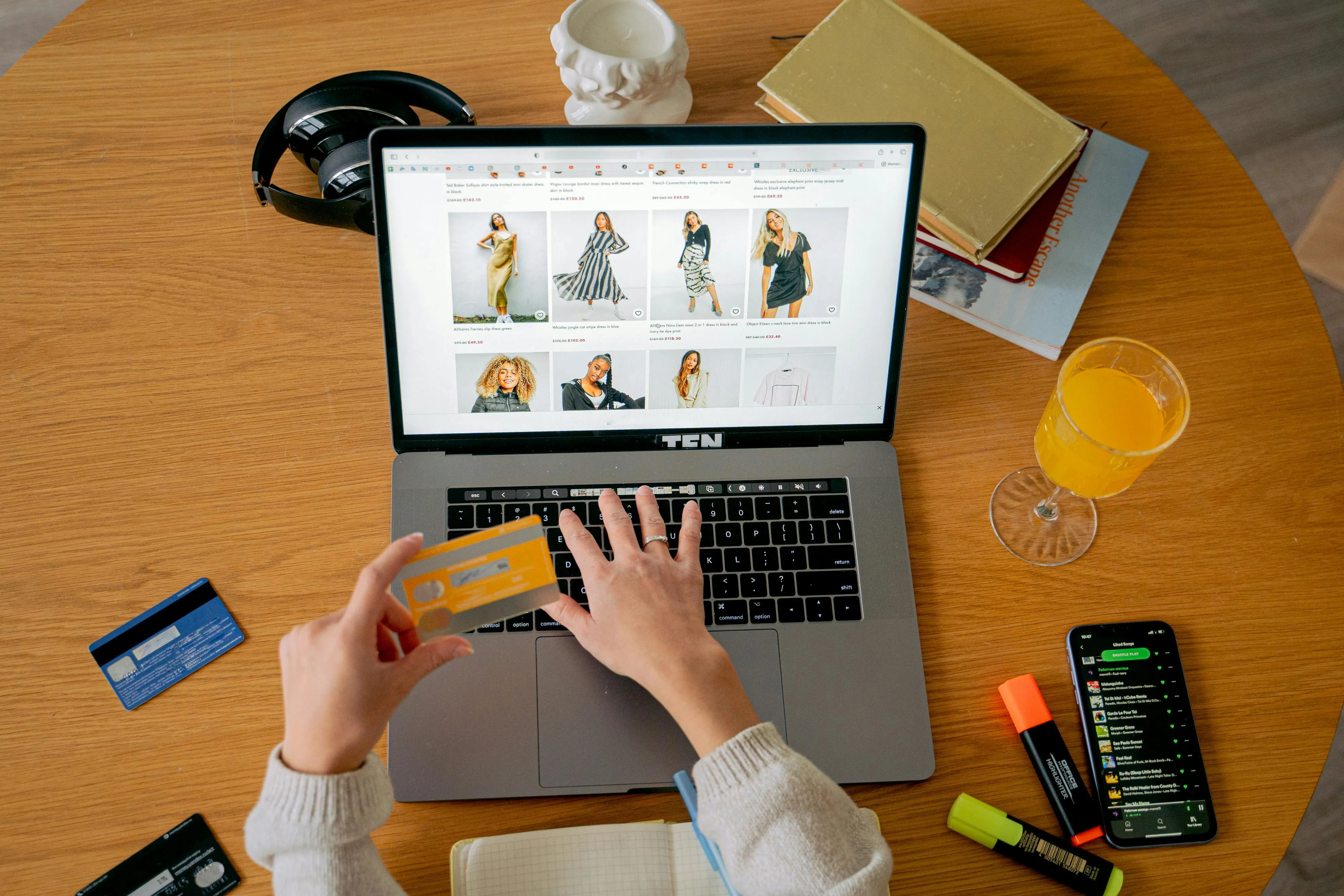 Woman shopping online for clothes on a laptop and entering credit card information for payment
